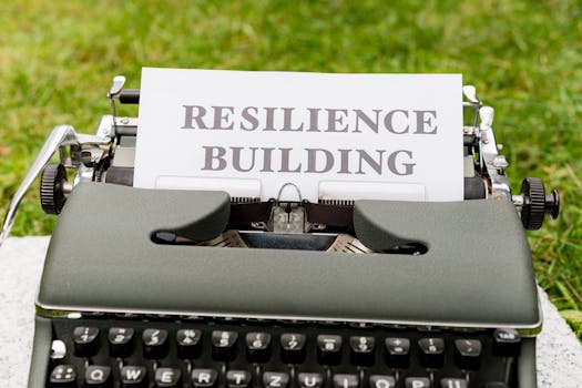 Vintage typewriter with 'Resilience Building' text on paper, set outdoors on grass.